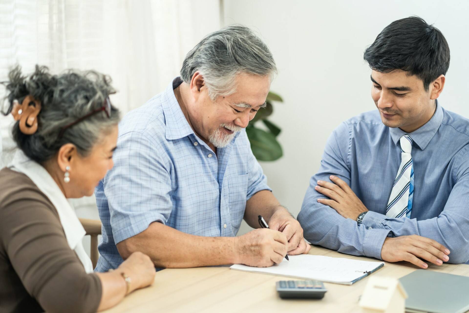 Asian couple senior elder making health insurance contract on table with agency visit at home.