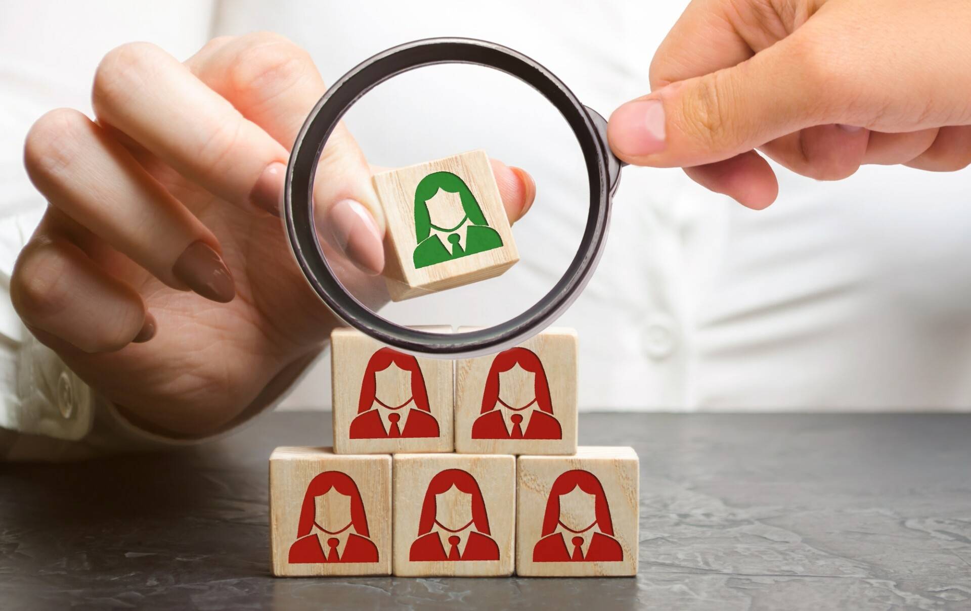 Businesswoman puts wooden blocks with the image of female employees