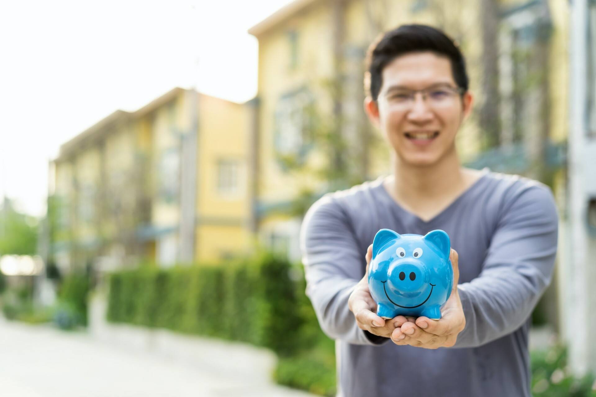 Happy asian man holding piggybank