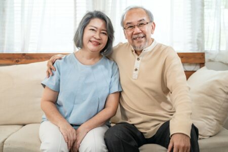 Happy Asian senior elder Couple in kitchen at home enjoy retirement life together and look at camera